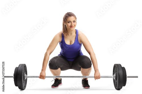 Cheerful young woman lifting weights and smiling at the camera