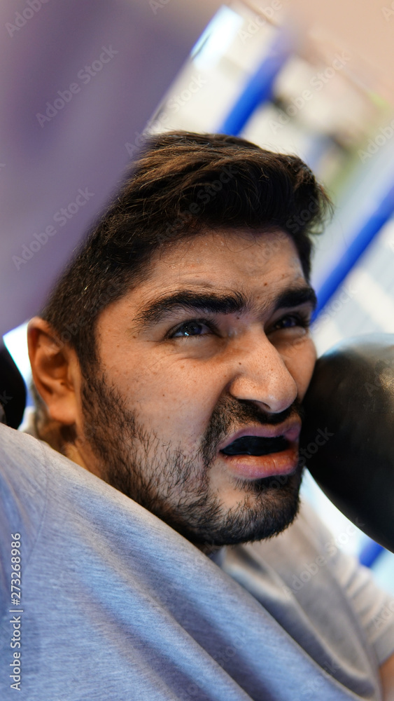 Cruel boxer with black beard standing in boxing pose Cruel boxer with black beard standing in boxing pose