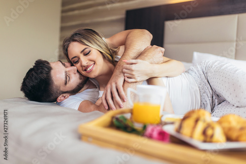 Romantic happy couple having breakfast in bed