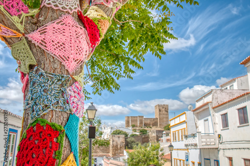 Trees decorated with colorful crochet patchwork on a holiday in the town of Mertola, a very beautiful city in the Portuguese Alentejo area photo