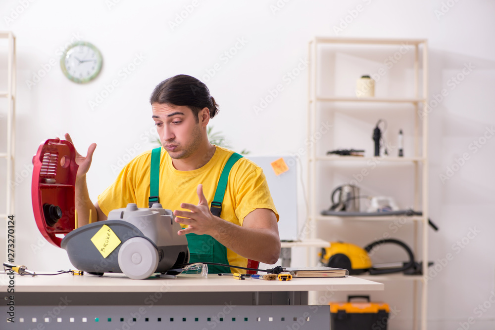 Man repairman repairing vacuum cleaner Man repairman repairing vacuum cleaner