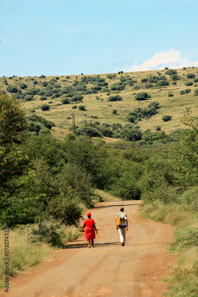 Black couple walking on a country road in South Africa Black couple walking on a country road in South Africa