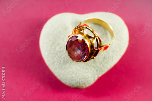 Ring with colored stone on a bright crimson background