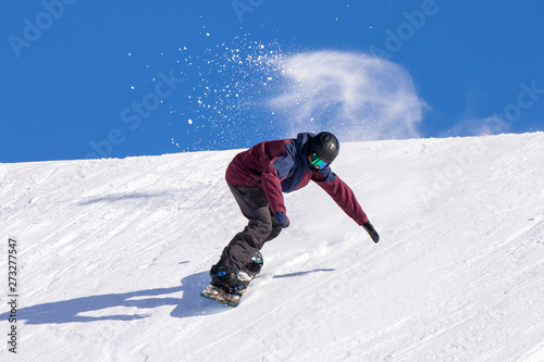 Snowboarder in azione su pista con neve fresca