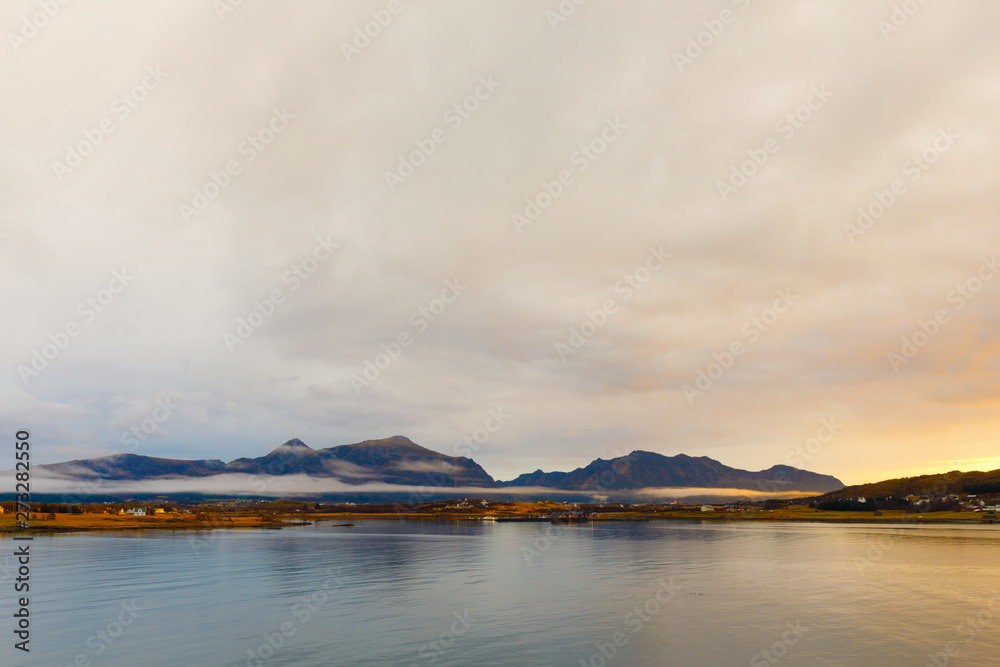 Sunset at fjord on Lofoten in Norway with mountains in background