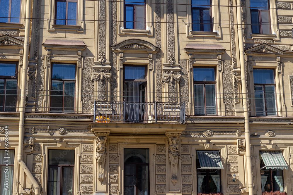 Wall of an old house with windows and balcony