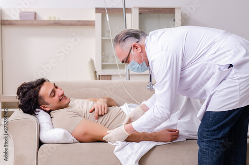 Old male doctor visiting young male patient 