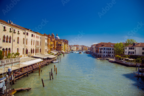 View of the Grand Canal in Venice. On both sides of the canal house, in the distance you can see the dome of the Church. In the distance the channel sailing boats and motor boats