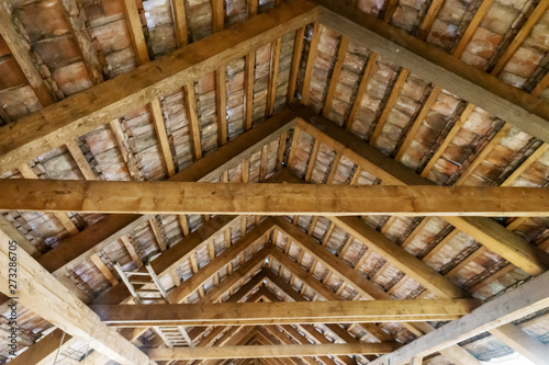Wooden ladder lies on the old attic