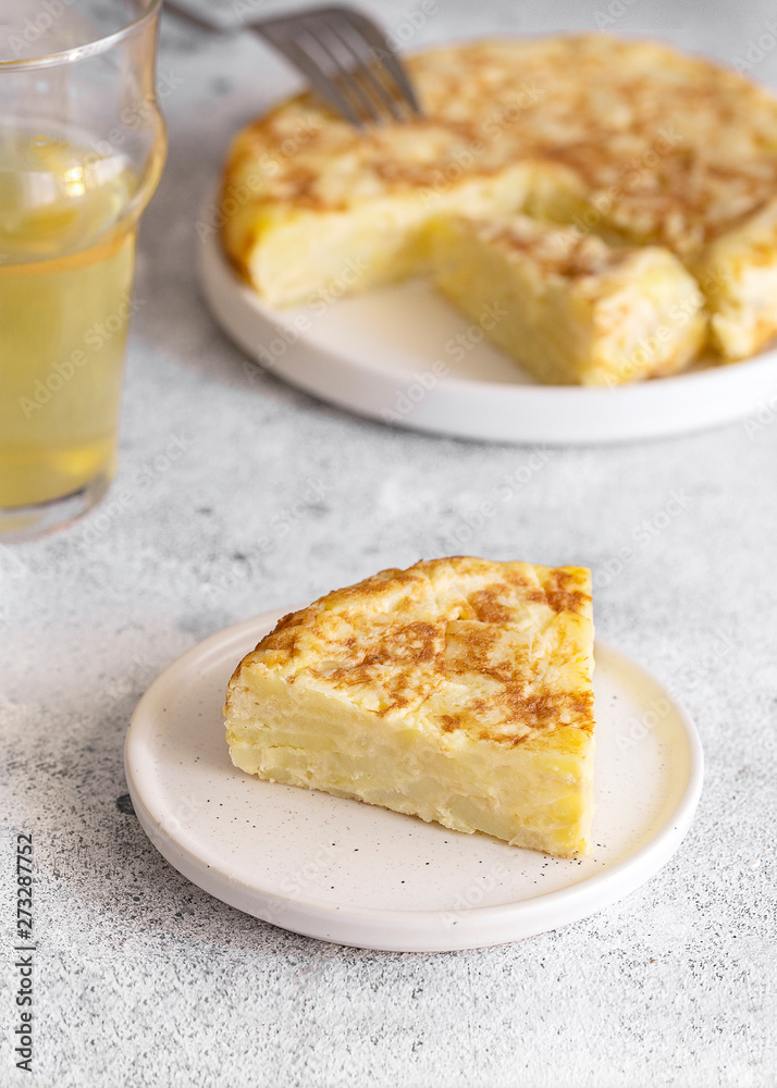 Tortilla, Spanish omelette made with eggs and potatoes. Traditional Spanish tapa served with slices of jamon, Iberian ham on white background. Tortilla, Spanish omelette made with eggs and potatoes. Traditional Spanish tapa served with slices of jamon, Iberian ham on white background.