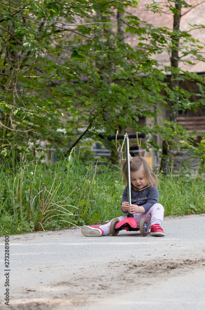 Fototapeta premium Scooter. Baby. Girl. Sitting. Forest. Cute