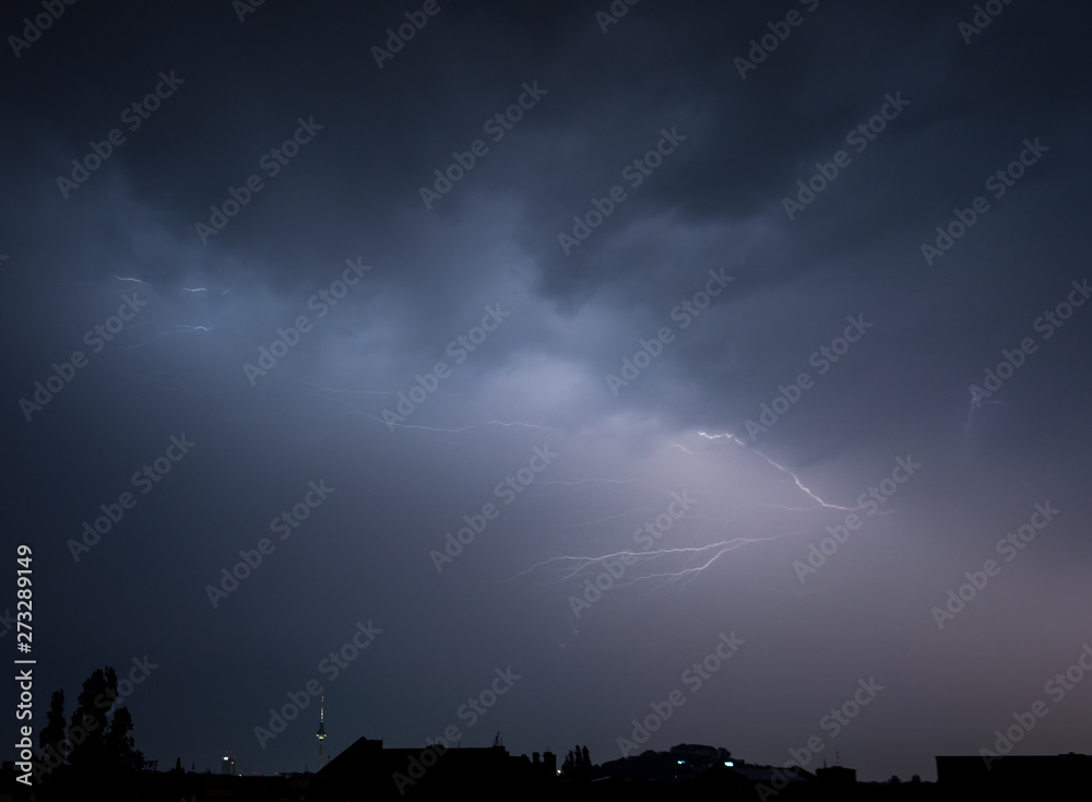 Discrete lightning bolts in the form of branches appearing over the city of Berlin during the electrical storm of 10.06.19. The Berlin tower is on the left, Germany