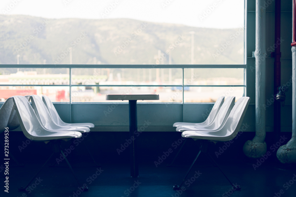 Fototapeta premium Side view on the seats with table on the deck of the ferryboat on the seaside travel ship