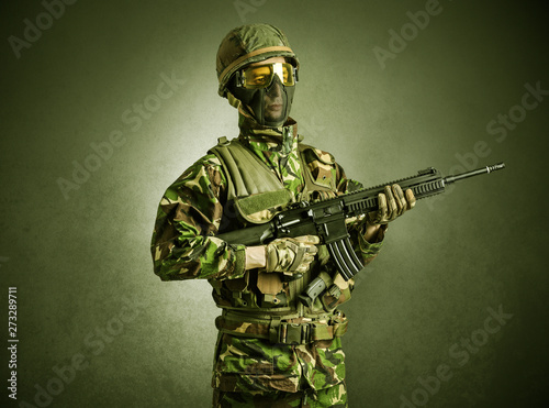 Soldier agent in a dark room with arms on his hand and gas mask
