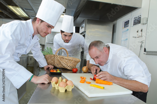 chef showing students how to chop vegetables with precision