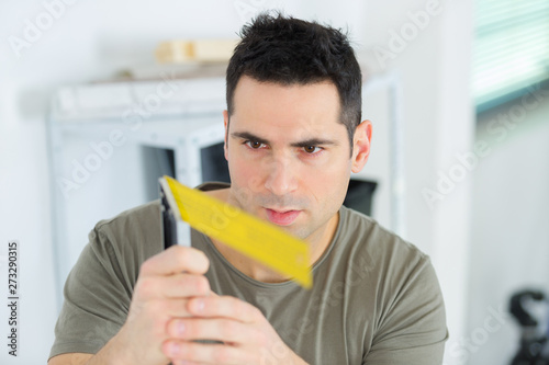 man examining yellow object he is holding