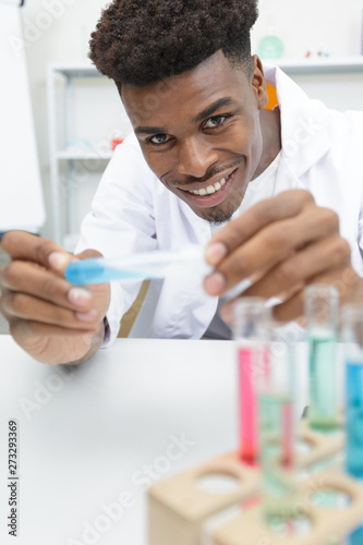 happy young pharmacist preparing medicine in lab photo
