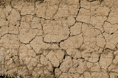 Texture of dry brown cracked earth. Lack of moisture on the soil, drought. The concept of dehydration land. Photo as wallpaper. Minimalistic background design. Place for text