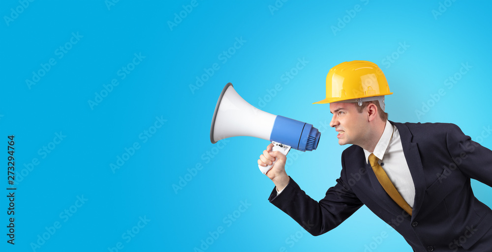 Young architect constructor yelling with megaphone and copyspace