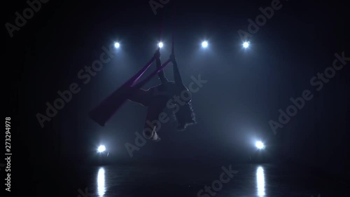 Girl aerial gymnast performing on a silk in a circus stage. Exciting acrobatic show. 075 photo