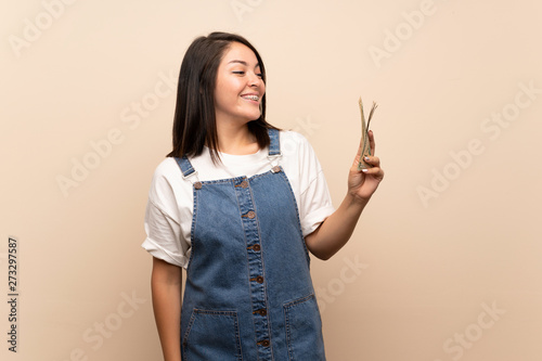 Young Mexican woman over isolated background taking a lot of money
