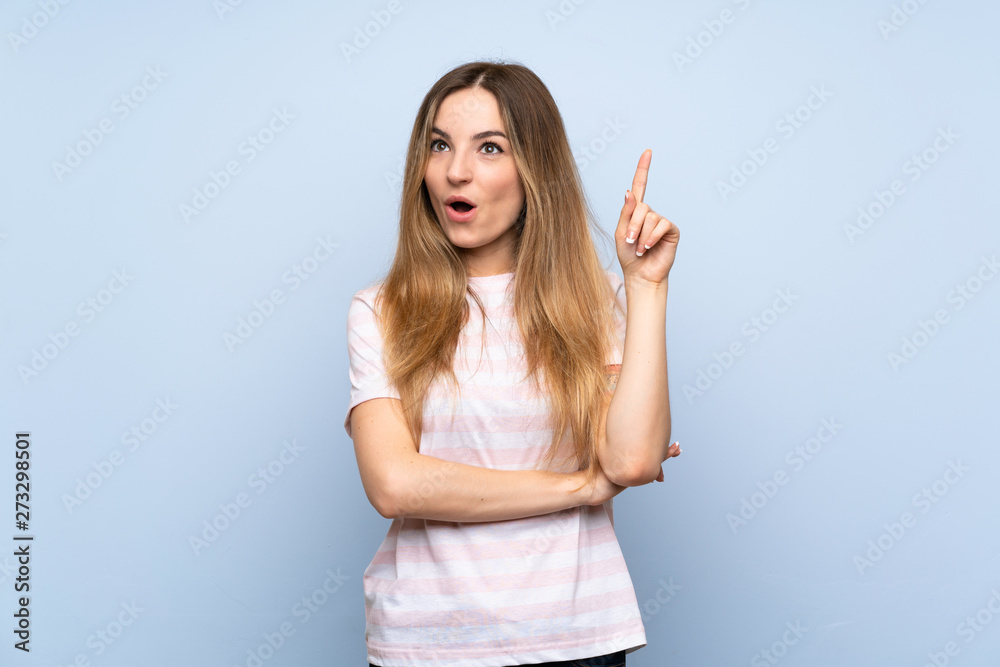 Young woman over isolated blue background thinking an idea pointing the finger up Young woman over isolated blue background thinking an idea pointing the finger up