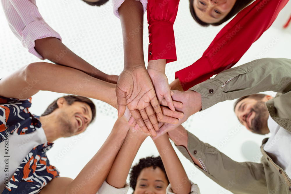 Business people forming hand stack in a modern office Business people forming hand stack in a modern office