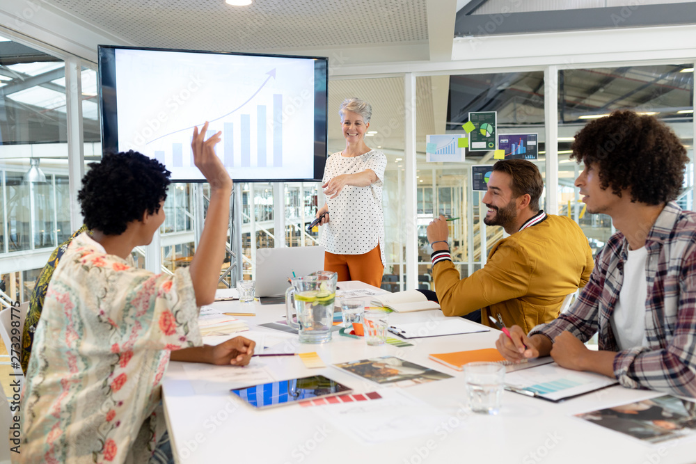Businessman raising hand in presentation during meeting in a modern office Businessman raising hand in presentation during meeting in a modern office