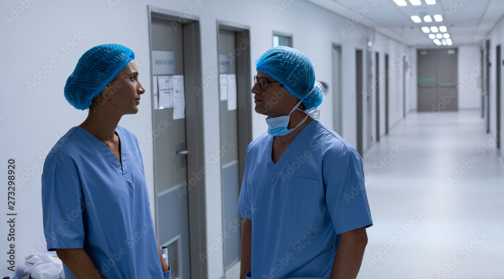Surgeons talking with each other in the corridor at hospital Surgeons talking with each other in the corridor at hospital