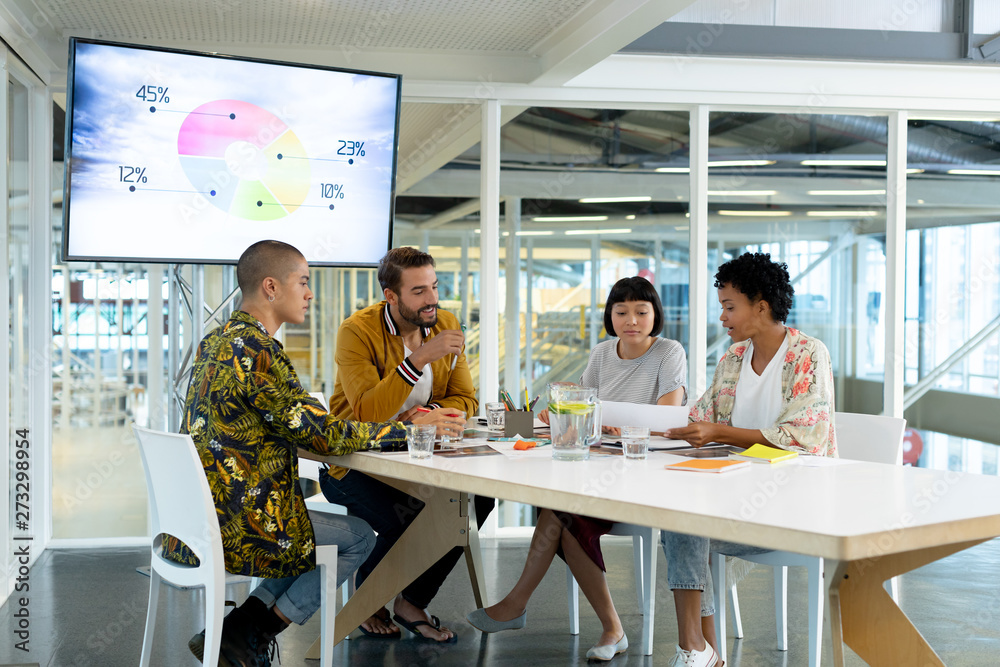 Business people discussing over documents in the conference room Business people discussing over documents in the conference room
