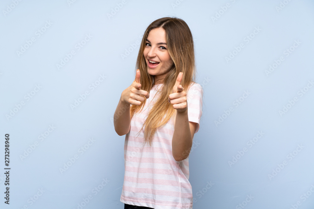Young woman over isolated blue background pointing to the front and smiling Young woman over isolated blue background pointing to the front and smiling