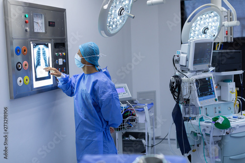 Male surgeon reading x ray in operating room