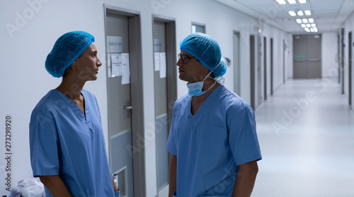 Surgeons talking with each other in the corridor at hospital