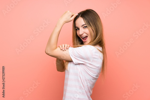 Young woman over isolated pink wall making strong gesture