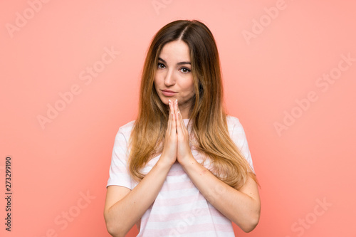 Young woman over isolated pink wall pleading