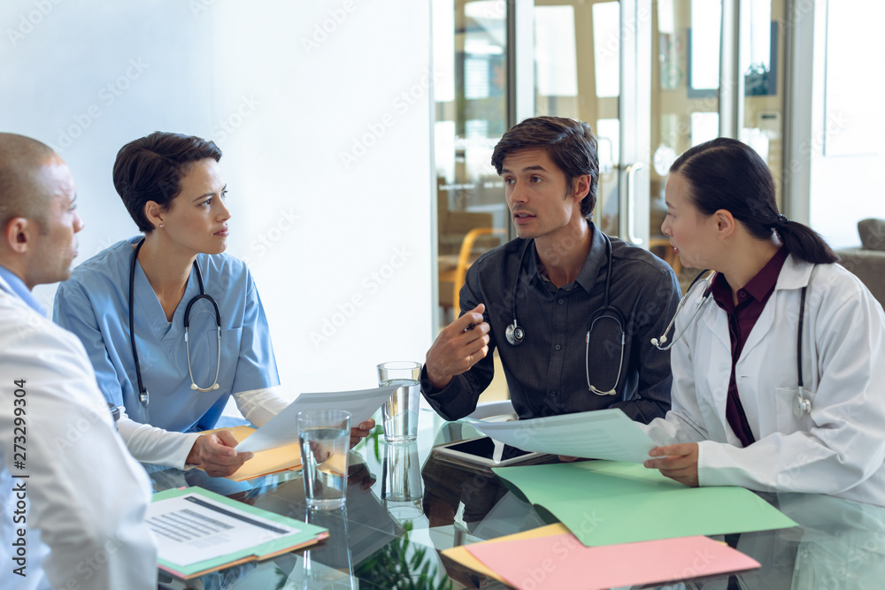 Medical team discussing with each other at the table in hospital Medical team discussing with each other at the table in hospital