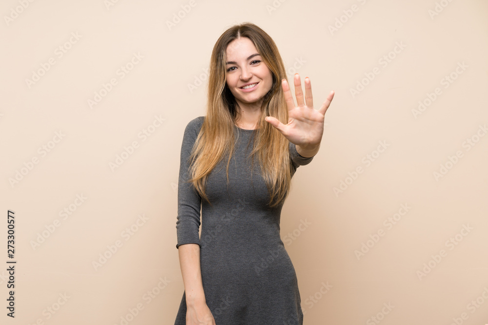 Young woman over isolated background counting five with fingers Young woman over isolated background counting five with fingers