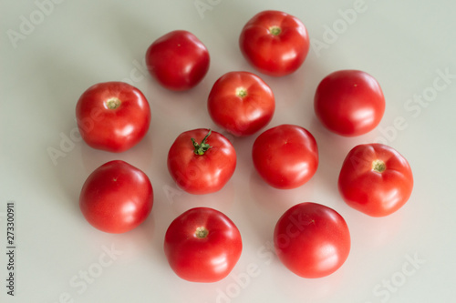 Fresh tomatoes on a white glass table. Harvesting tomatoes. Top view.