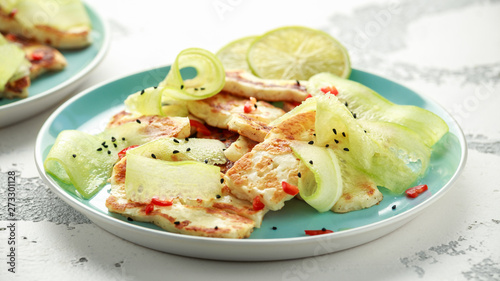 Halloumi cheese with lime dressed, cucumbers, chilli and nigella seeds on plate