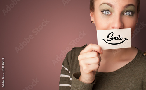 Person holding card with smile in front of her mouth 