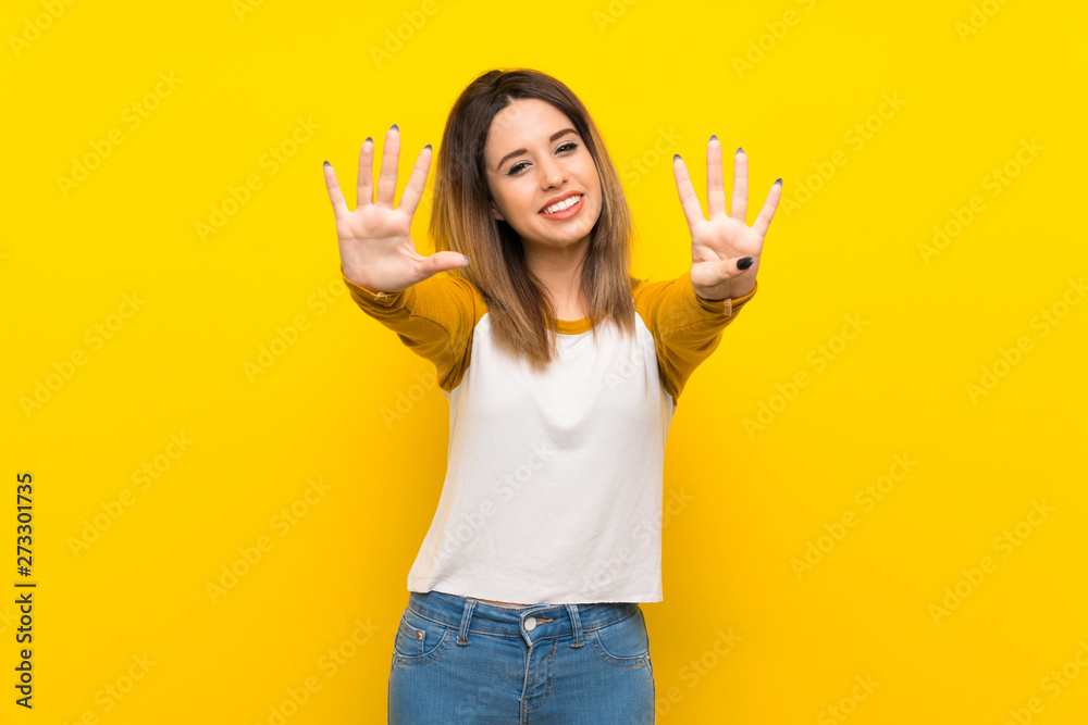 Pretty young woman over isolated yellow wall counting nine with fingers Pretty young woman over isolated yellow wall counting nine with fingers