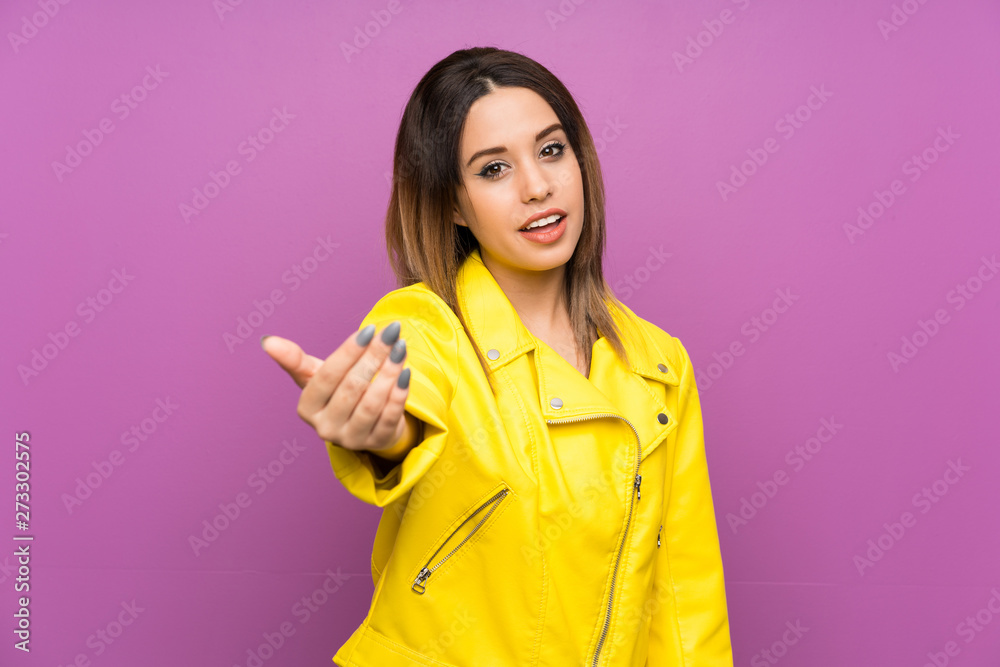 Young woman over purple background inviting to come Young woman over purple background inviting to come