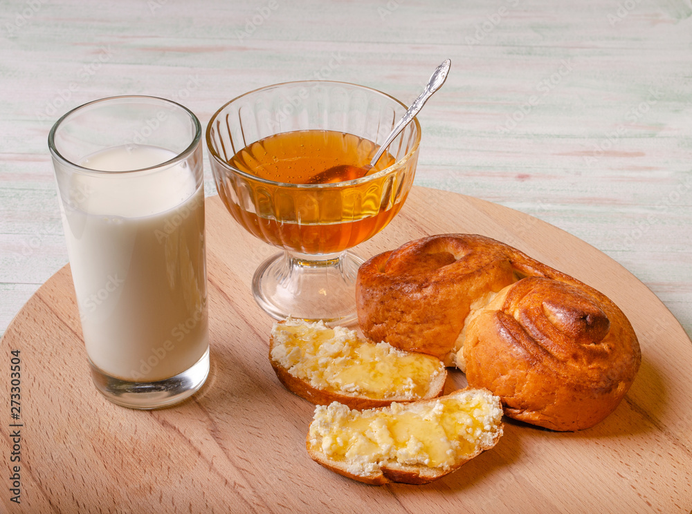 photo Breakfast glass of milk, bun bun, honey in a bowl and sandwiches with cottage cheese poured with honey photo Breakfast glass of milk, bun bun, honey in a bowl and sandwiches with cottage cheese poured with honey