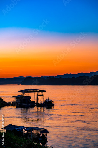 Beautiful Silhouette Orange Sunset on the Lake Hill with Many Birds Flying. © athurfotolia