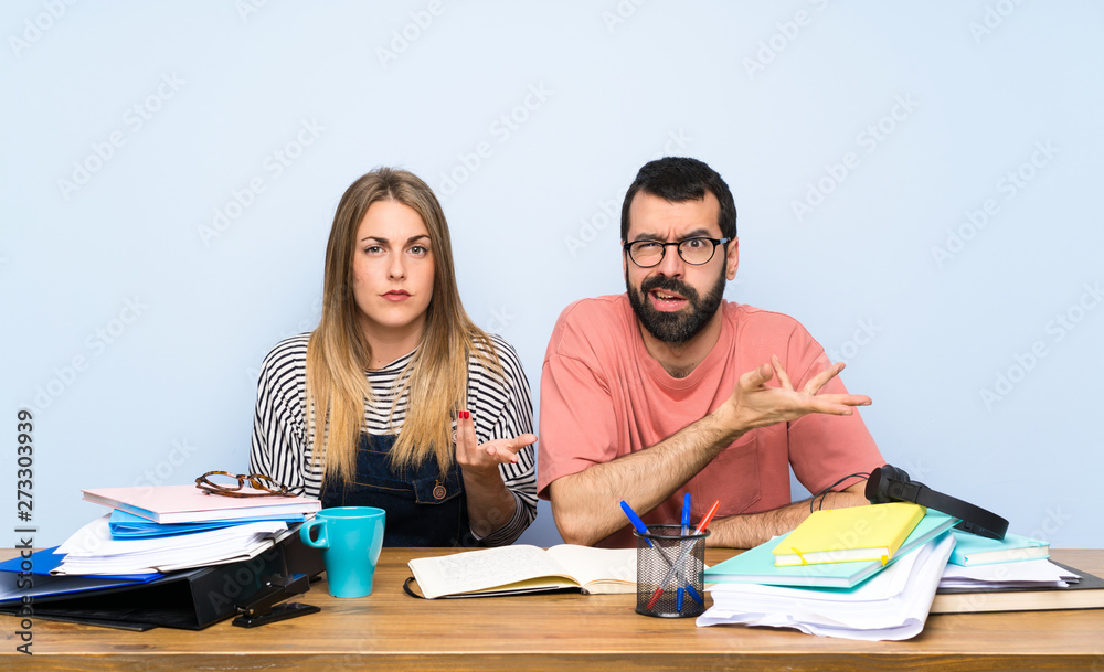 Students with many books making doubts gesture Students with many books making doubts gesture