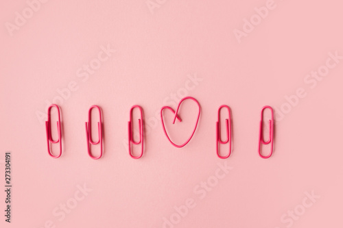 Quadro em tela Several pink paper clips in a row. One heart shaped.