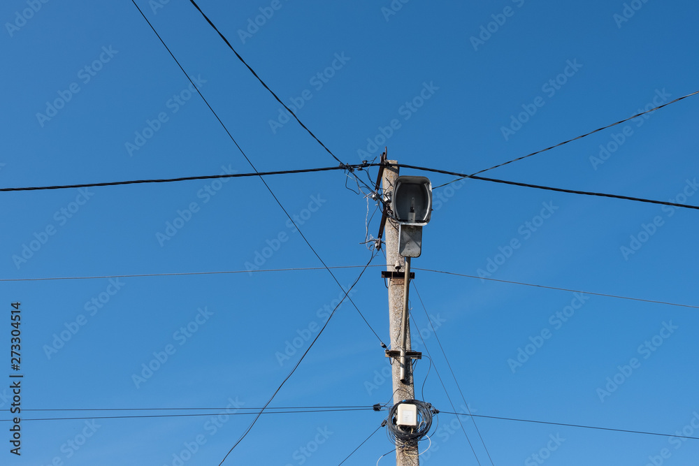 Street lamppost with wires. Concrete pole with a lantern. Street lamp without lamp.
