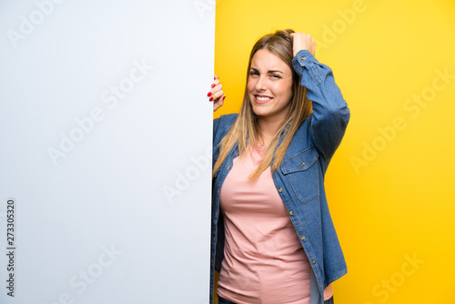 Young woman holding an empty placard unhappy and frustrated with something. Negative facial expression
