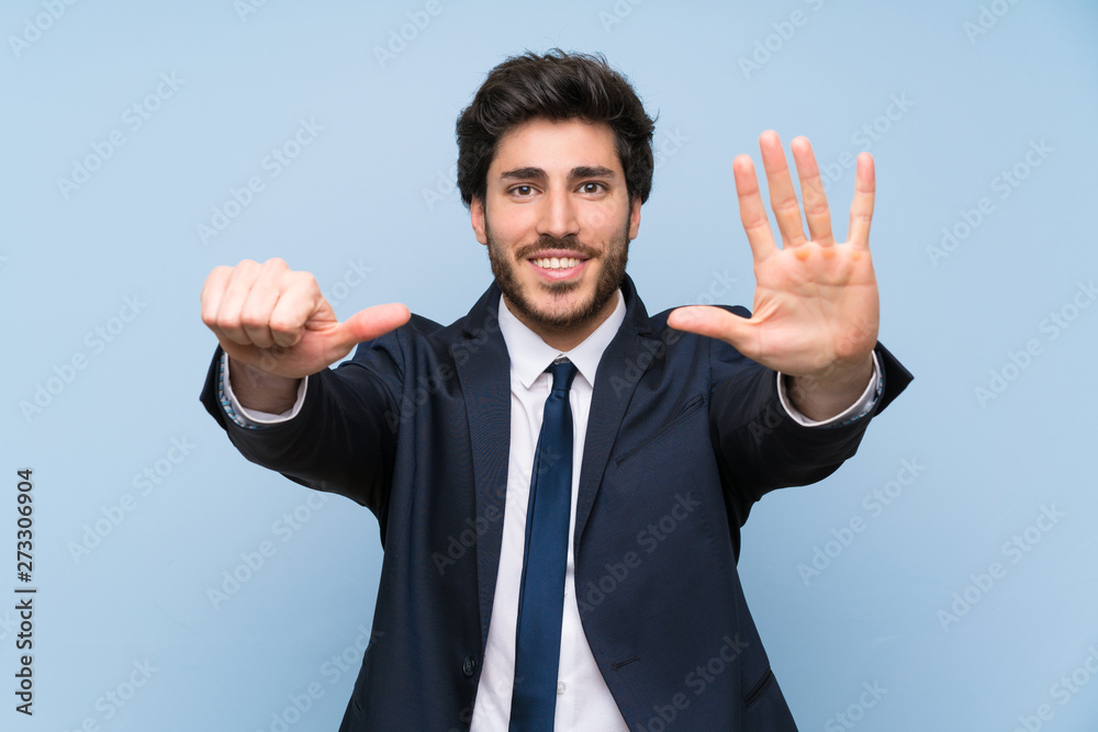 Businessman over isolated blue wall counting six with fingers
