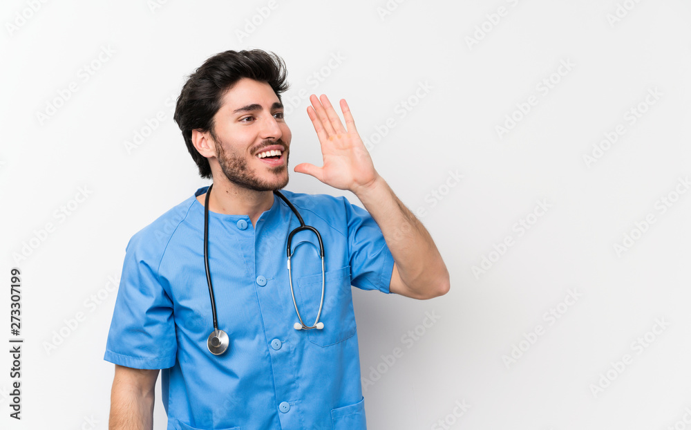 Surgeon doctor man over isolated white wall shouting with mouth wide open Surgeon doctor man over isolated white wall shouting with mouth wide open